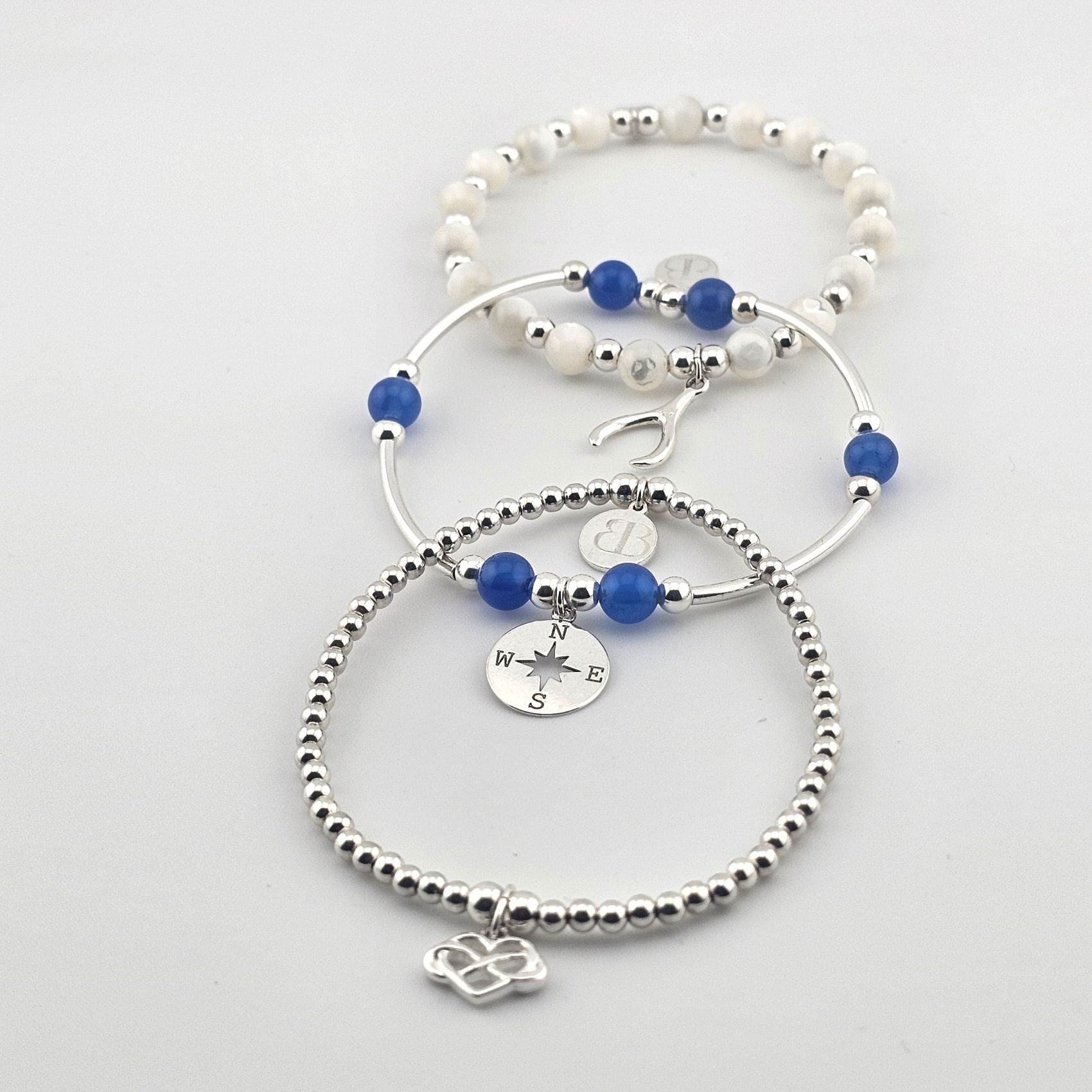 Bessie Bae sterling silver and blue beaded ocean-inspired bracelets featuring mermaid, anchor, and infinity charms.