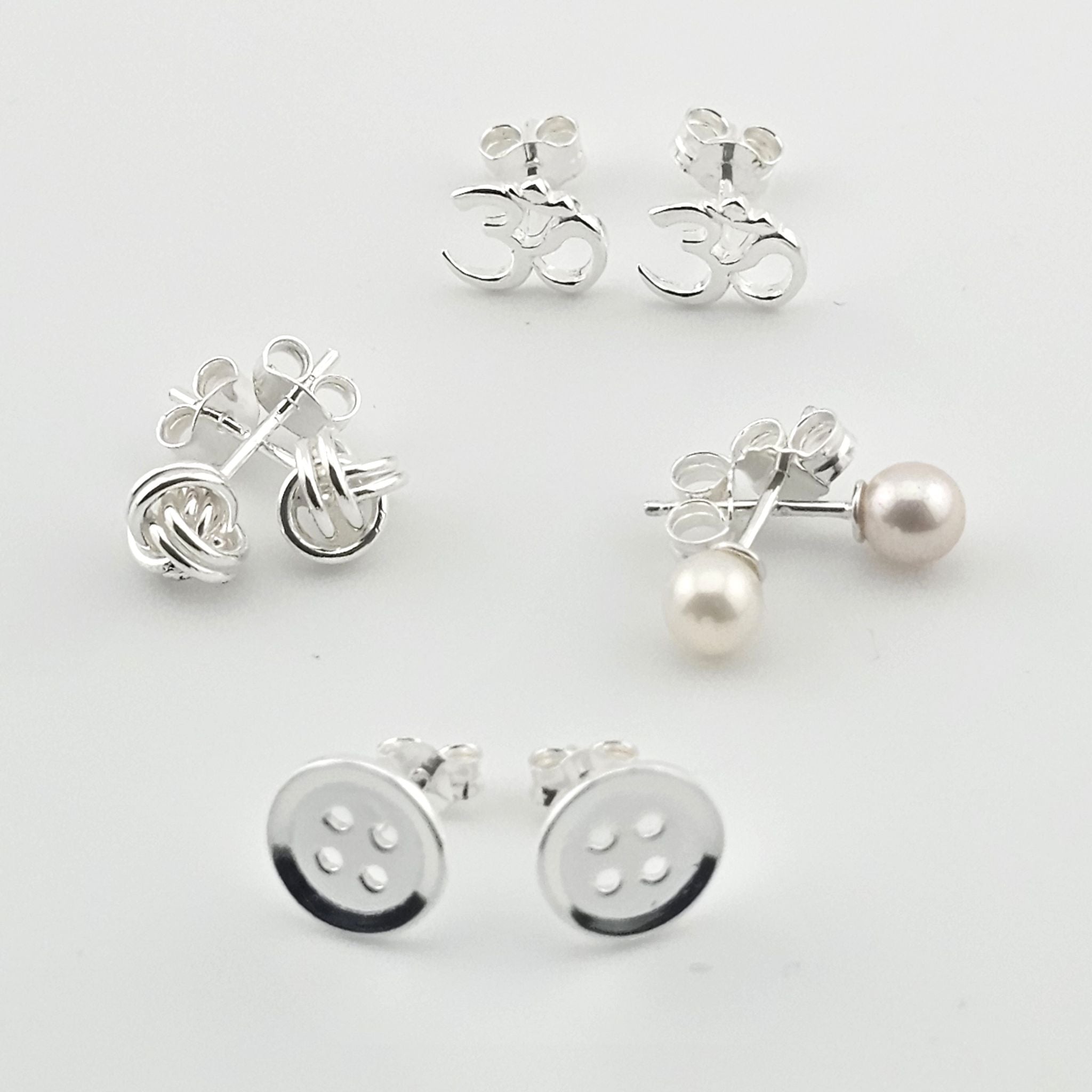 Bessie Bae sterling silver stud earrings set featuring minimalist designs with pearls, crystals, and polished round styles on a white background.