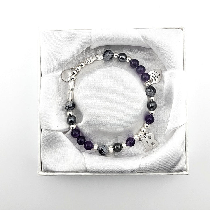 Bessie Bae packaging with Sterling Silver 18 charm bracelet presented in white satin-lined gift box.