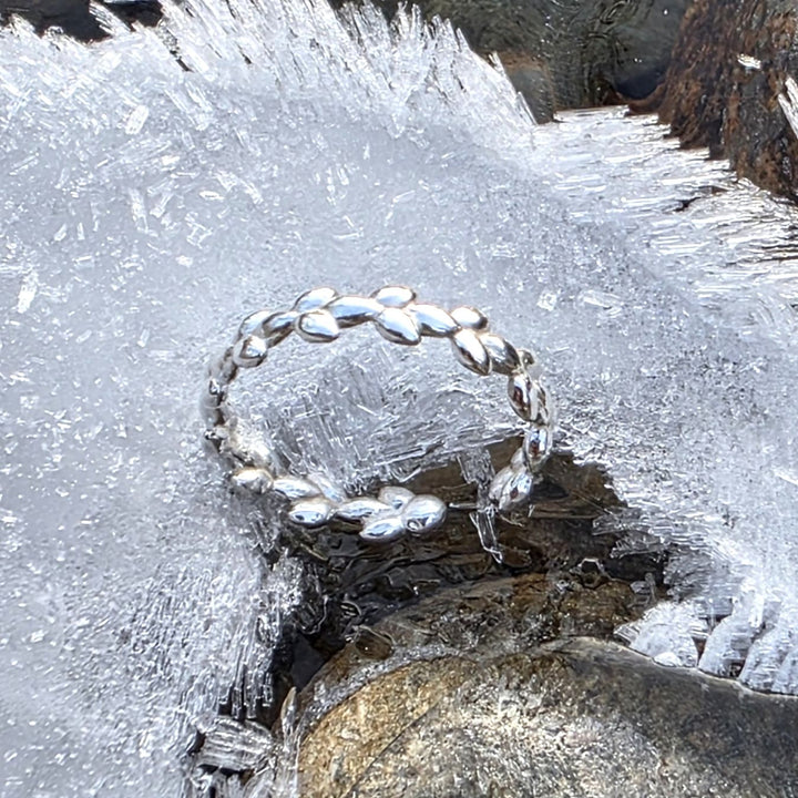 Sterling silver crimson leaves ring photographed on frozen ice and stone, inspired by winter nature by Bessie Bae.