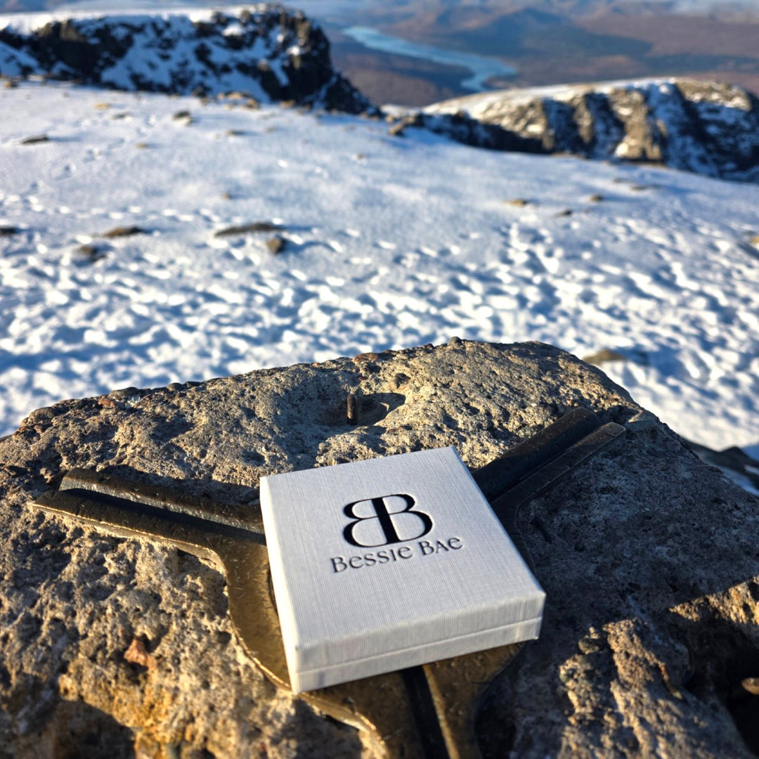 Bessie Bae jewellery gift box placed on a mountain rock with snowy landscape in the background.