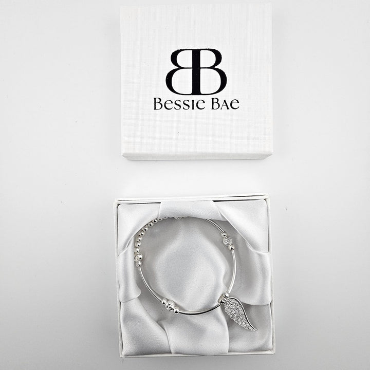 Sterling silver angel wing charm bracelet presented in Bessie Bae gift box.