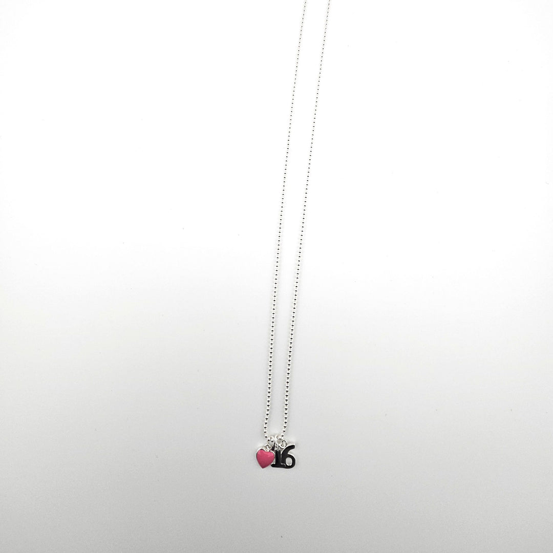 Sterling silver 16th birthday necklace with pink heart charm on a light background.