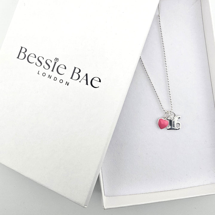 Sterling silver 16th birthday heart necklace shown beside Bessie Bae branded packaging.