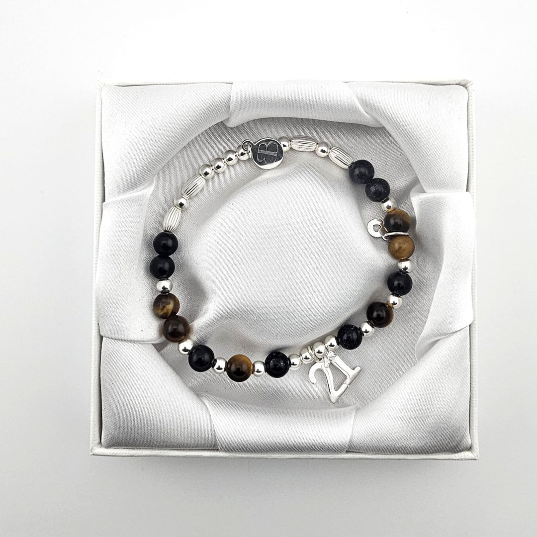 Bessie Bae branded packaging with Sterling Silver 21 charm bracelet presented inside white gift box.