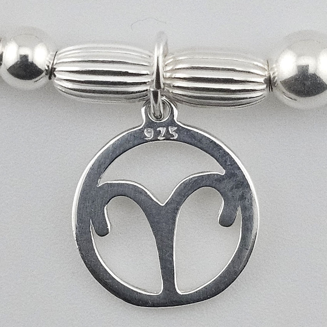 Close-up of sterling silver Aries zodiac charm.