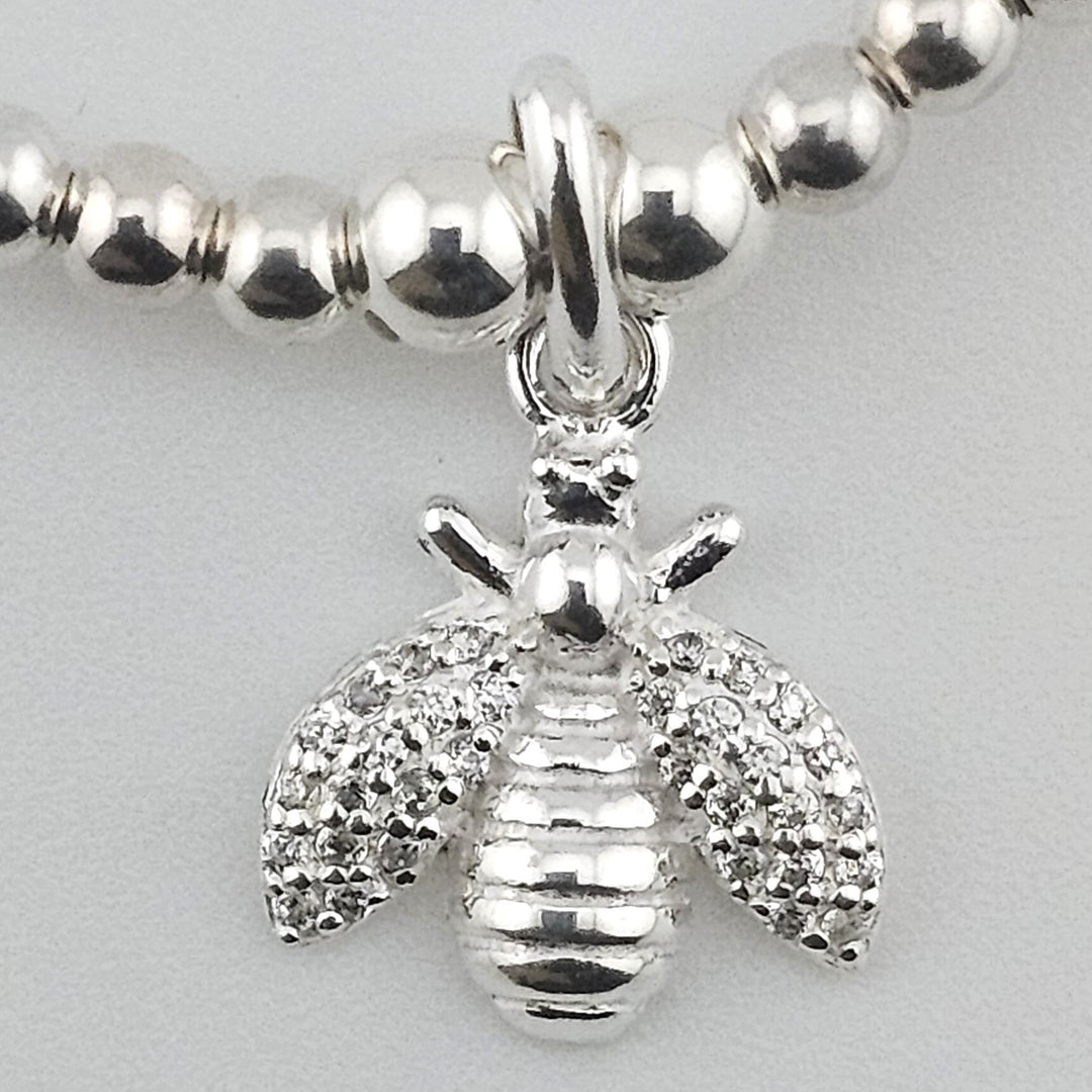 Close-up of detailed bee charm in sterling silver.