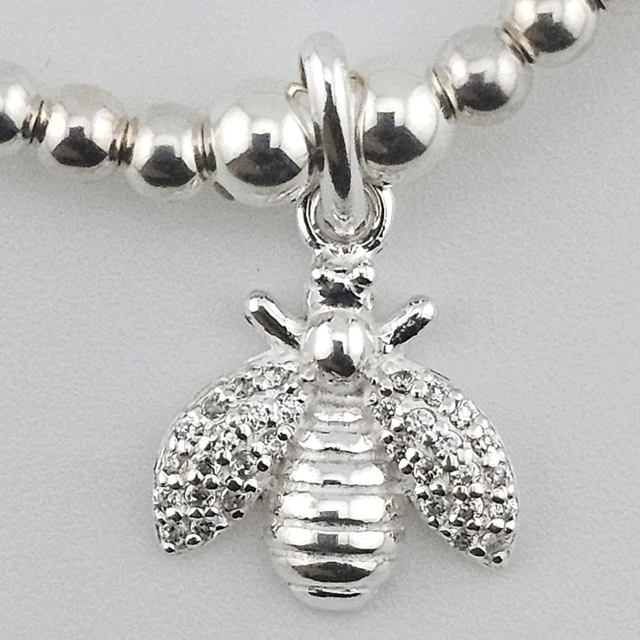 Close-up of detailed bee charm in sterling silver.