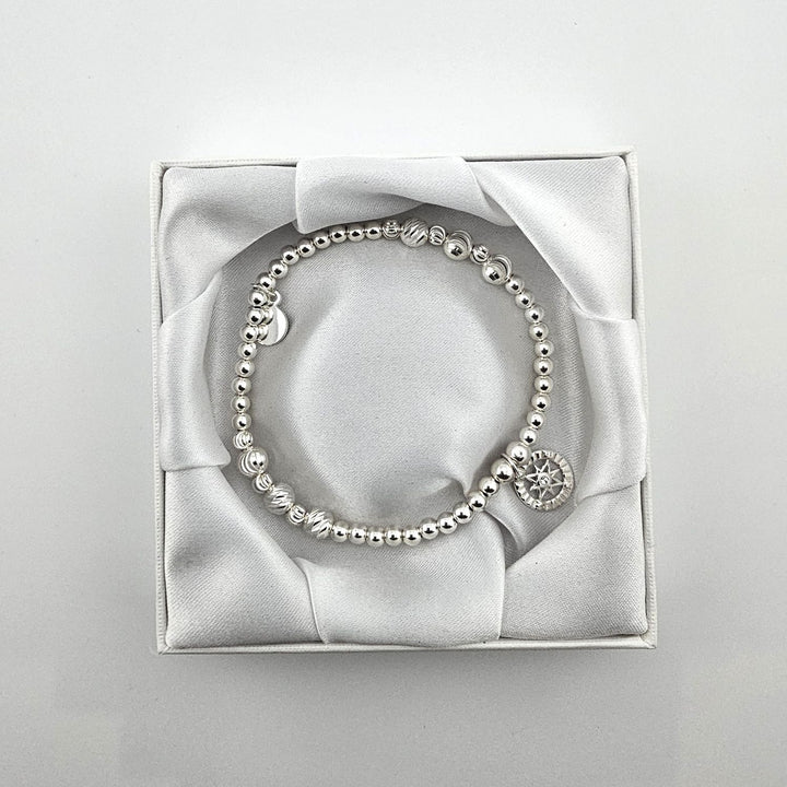 Sterling silver compass bracelet in white satin gift box.