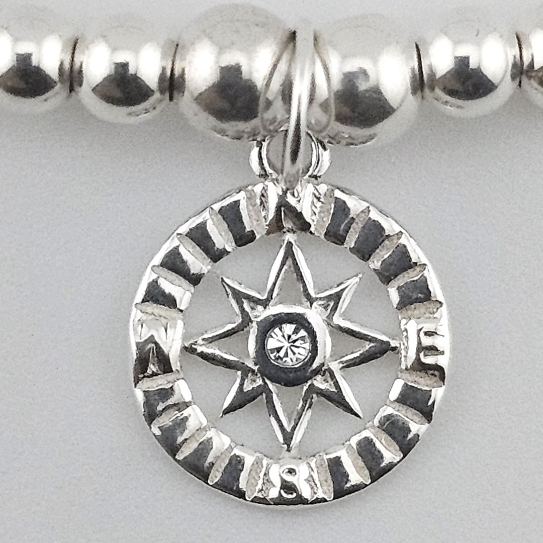 Close-up of compass charm with crystal centre.