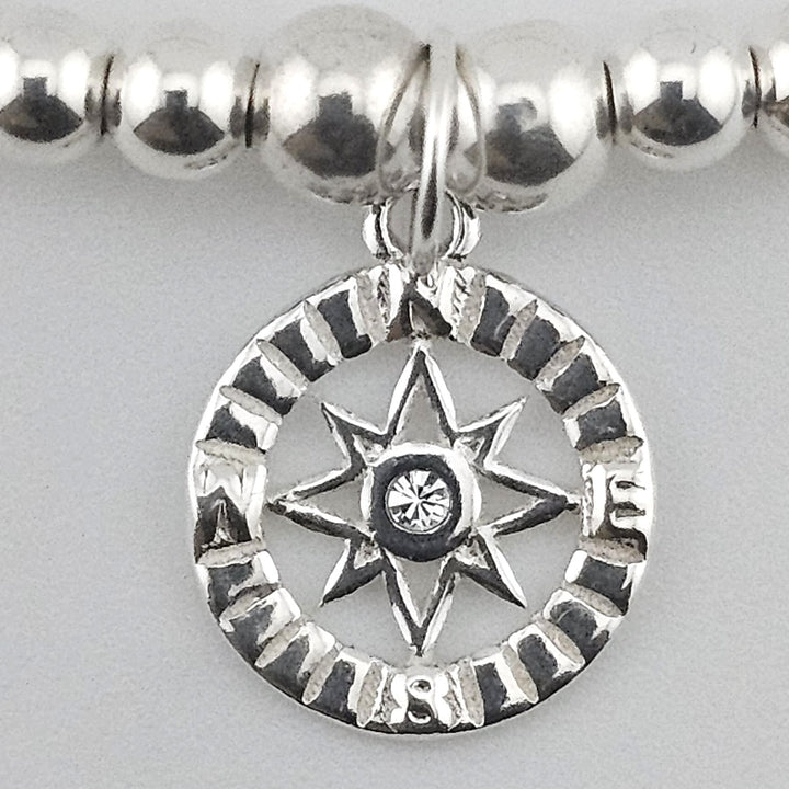 Close-up of compass charm with crystal centre.