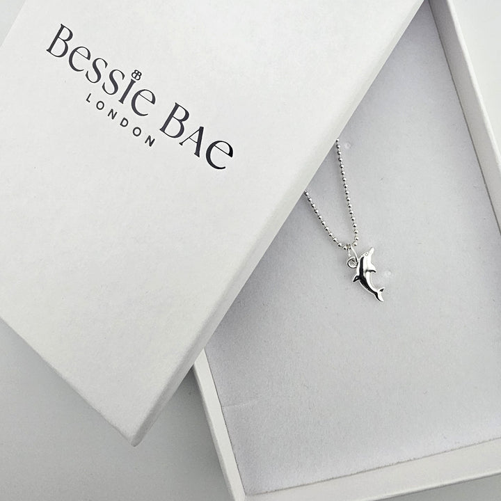 Sterling silver dolphin necklace presented in a Bessie Bae gift box.
