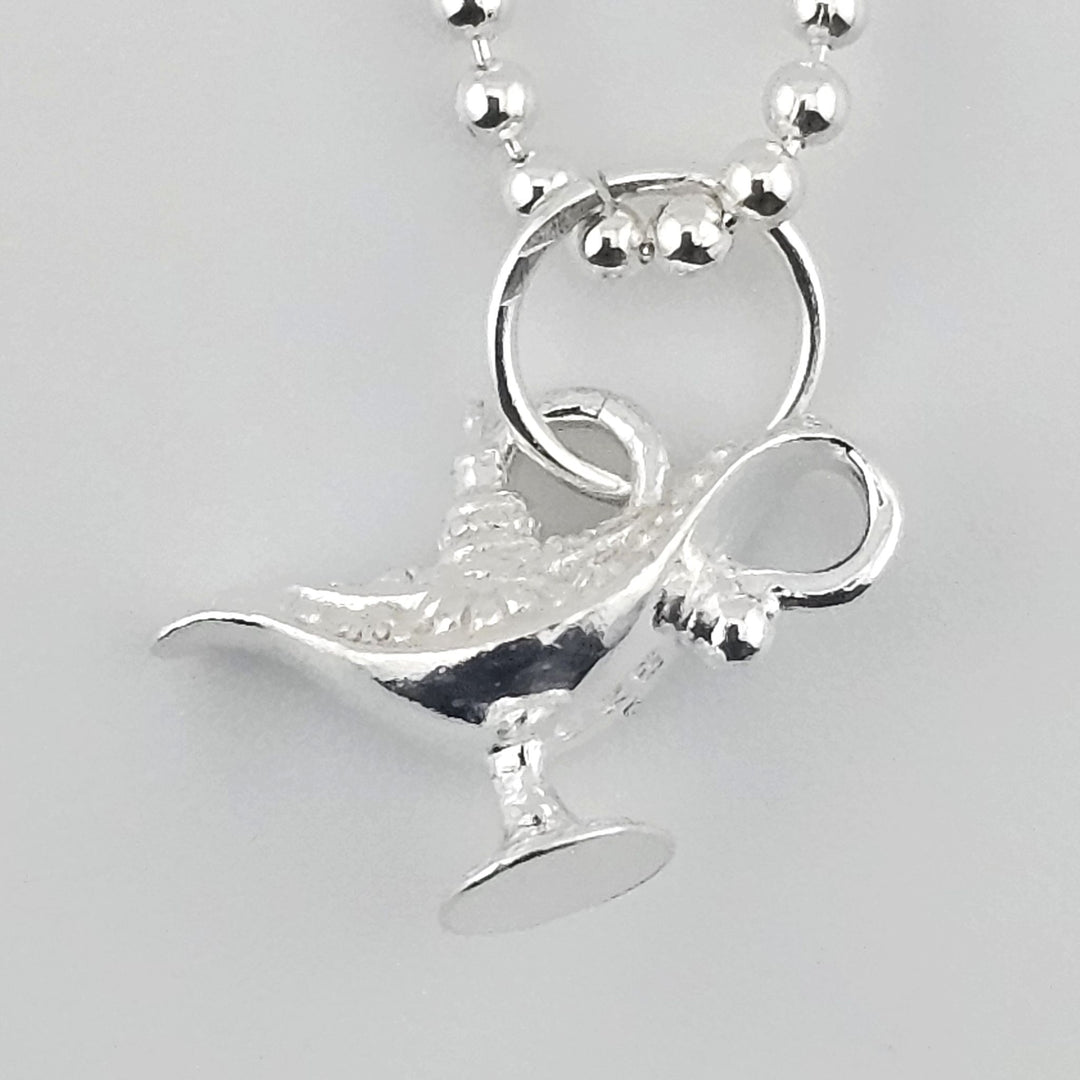 Close-up of sterling silver genie’s lamp pendant with textured detailing.