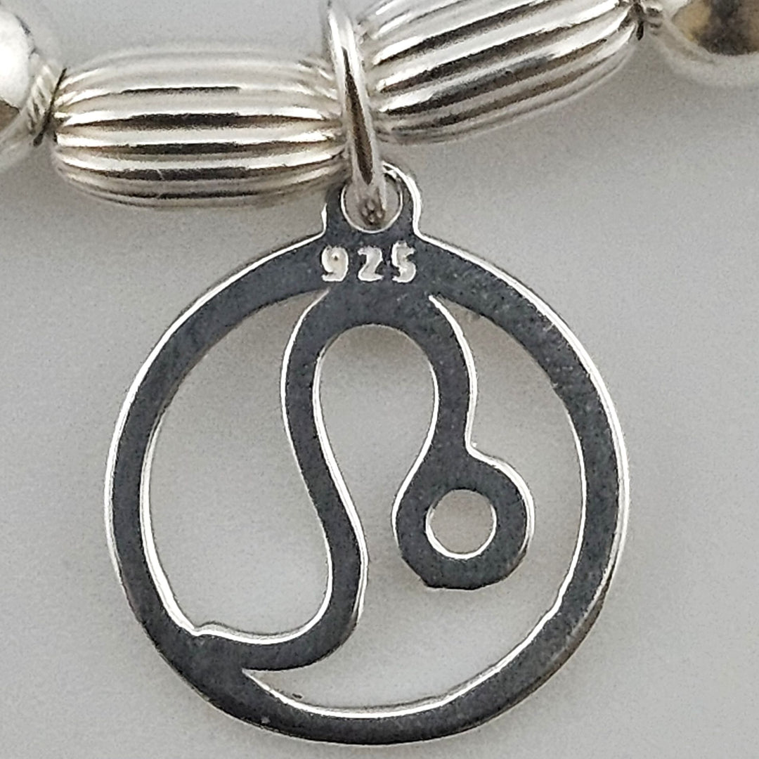 Close-up of sterling silver Leo zodiac charm.