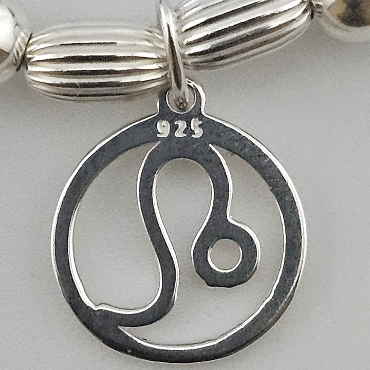 Close-up of sterling silver Leo zodiac charm.