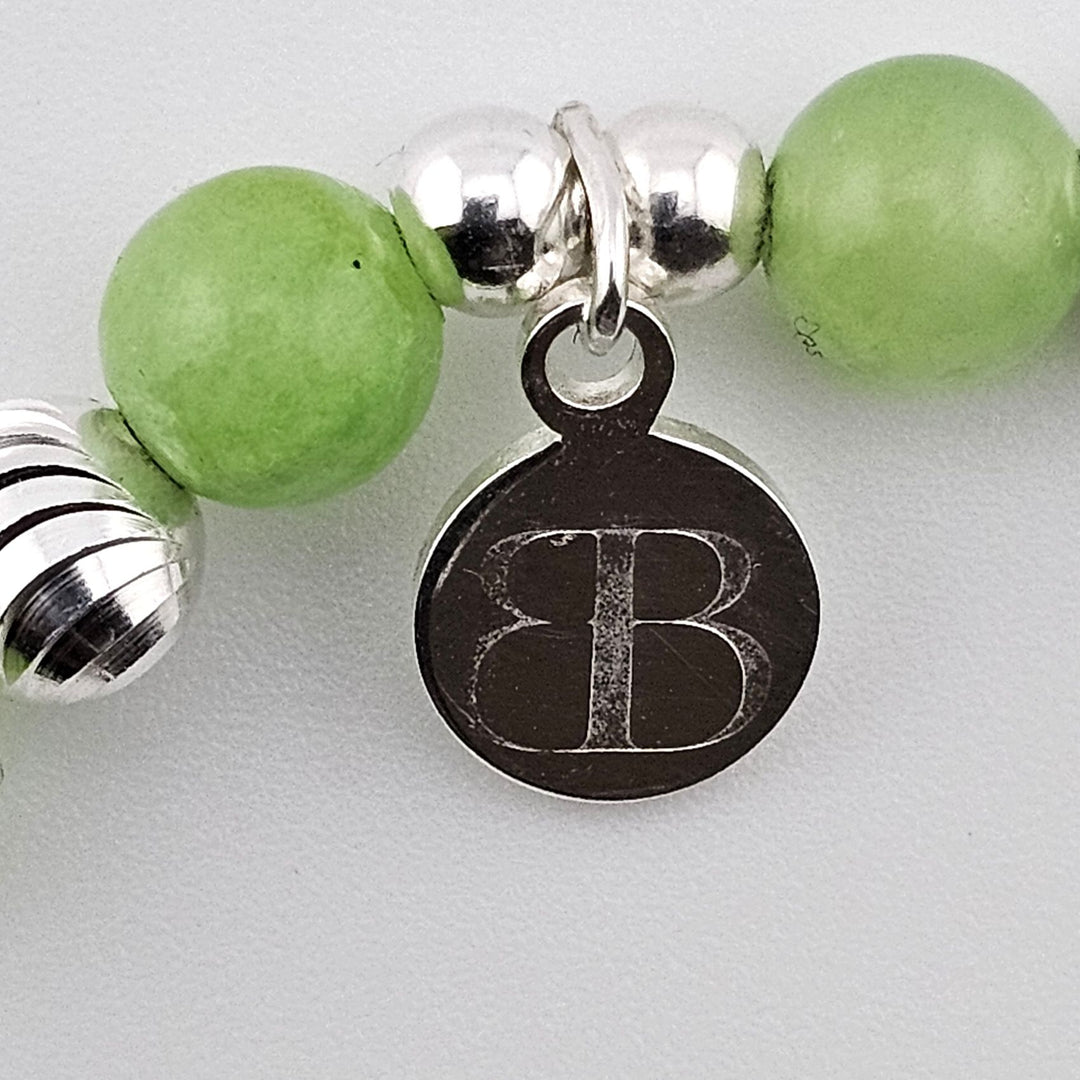 Bessie Bae logo charm on green aventurine and silver bracelet.