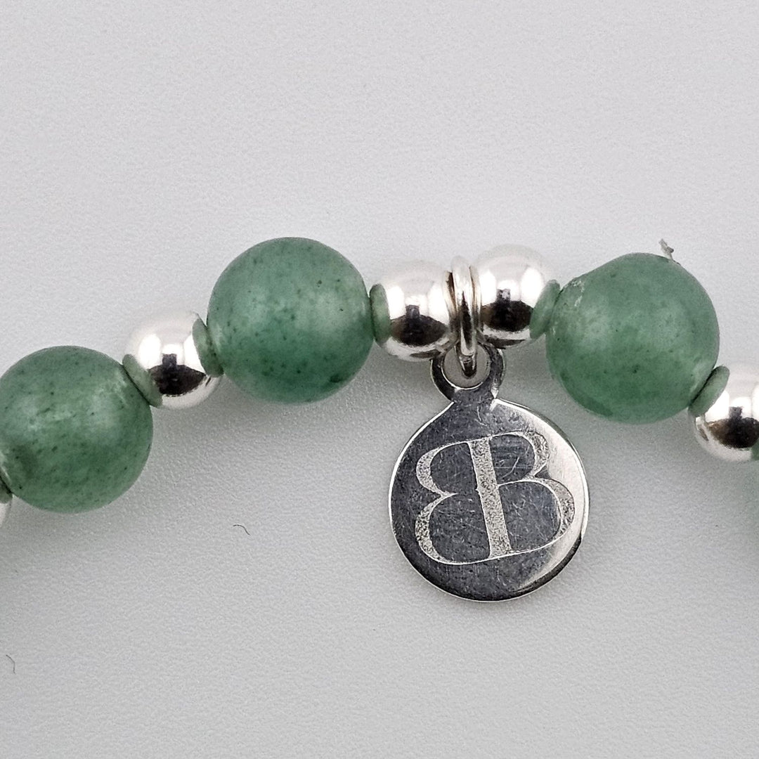 Bessie Bae logo tag attached to green aventurine gemstone bracelet.