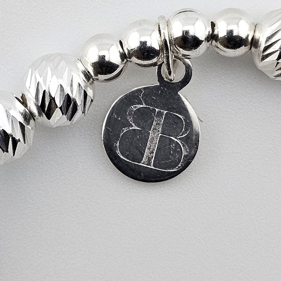 Bessie Bae logo tag attached to sterling silver snowflake bracelet.