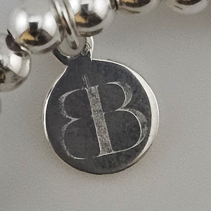 Bessie Bae logo tag on handcrafted Sterling Silver Button Bracelet.