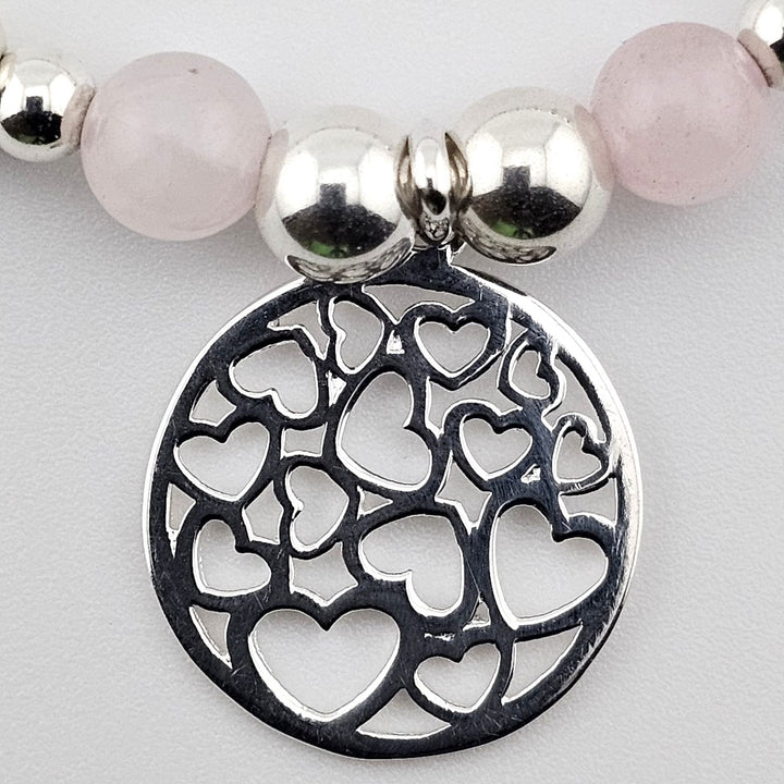 Close-up of open heart charm in sterling silver.