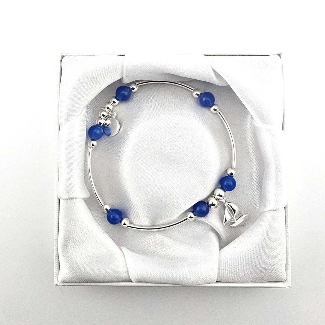 Sterling silver and blue gemstone bracelet with sailboat charm.
