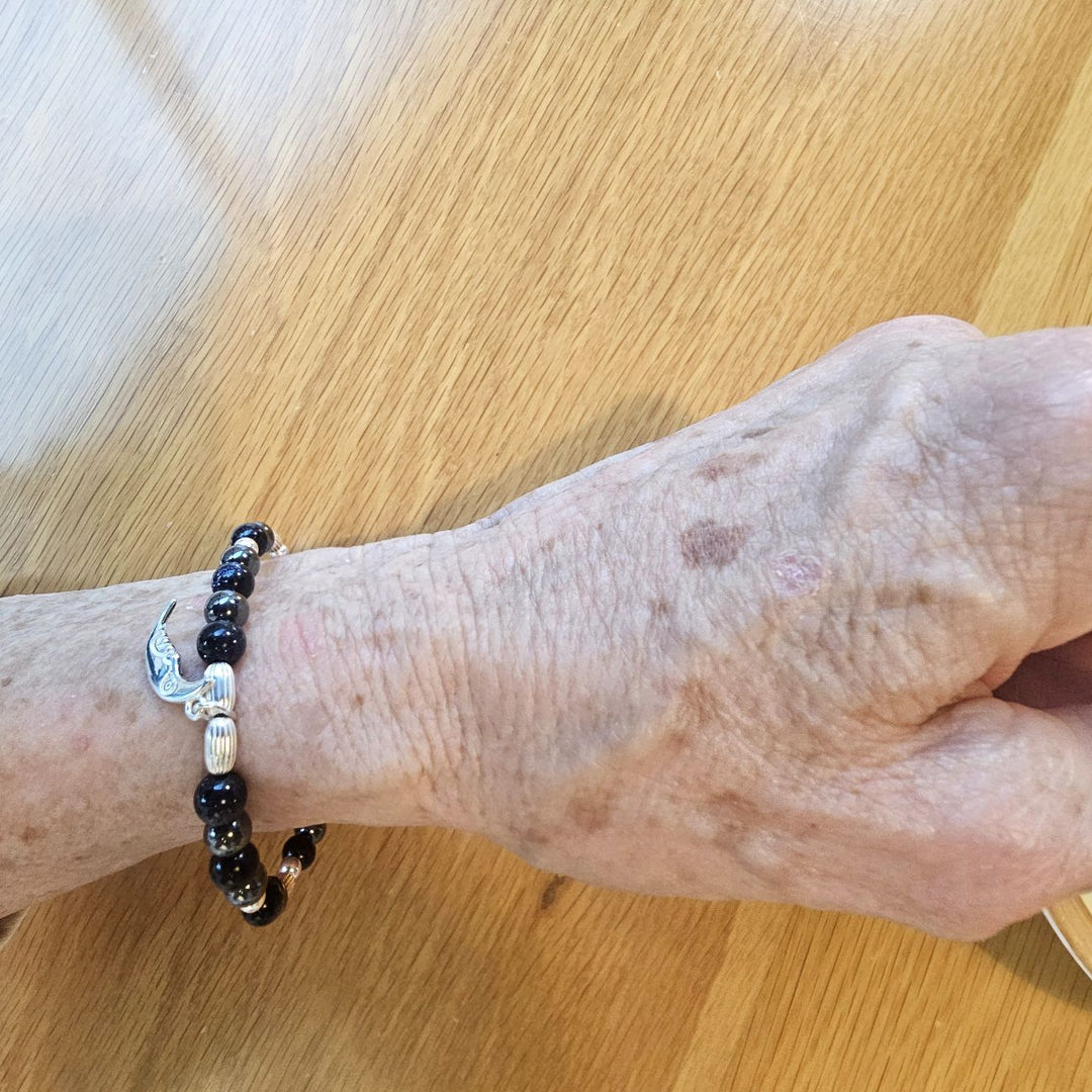 Silver crescent moon bracelet with blue goldstone and hematite.