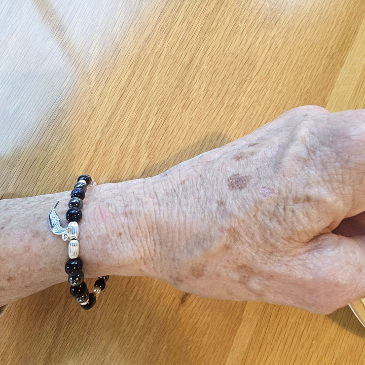 Silver crescent moon bracelet with blue goldstone and hematite.
