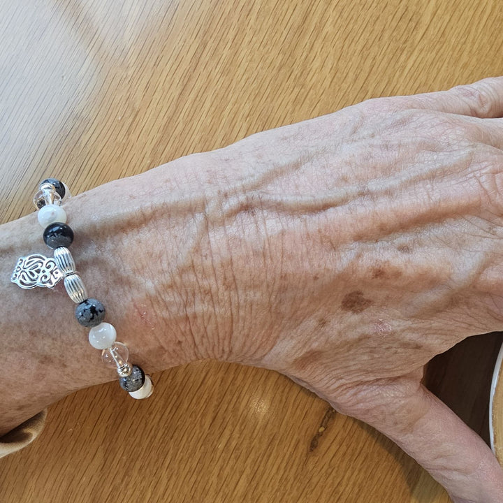 Silver owl bracelet with obsidian, pearl, and quartz.