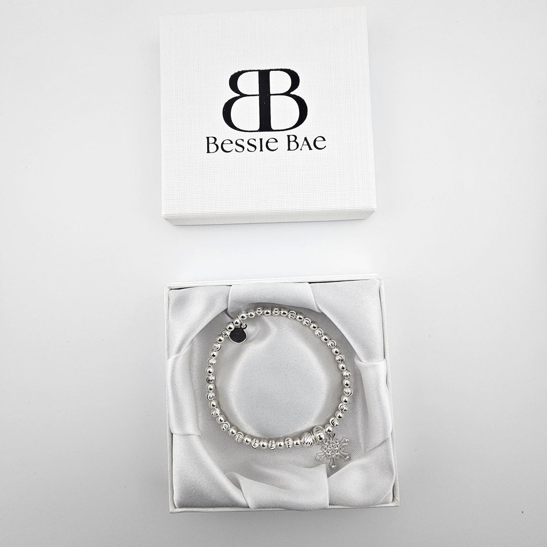 Snowflake charm sterling silver bracelet in white gift box.