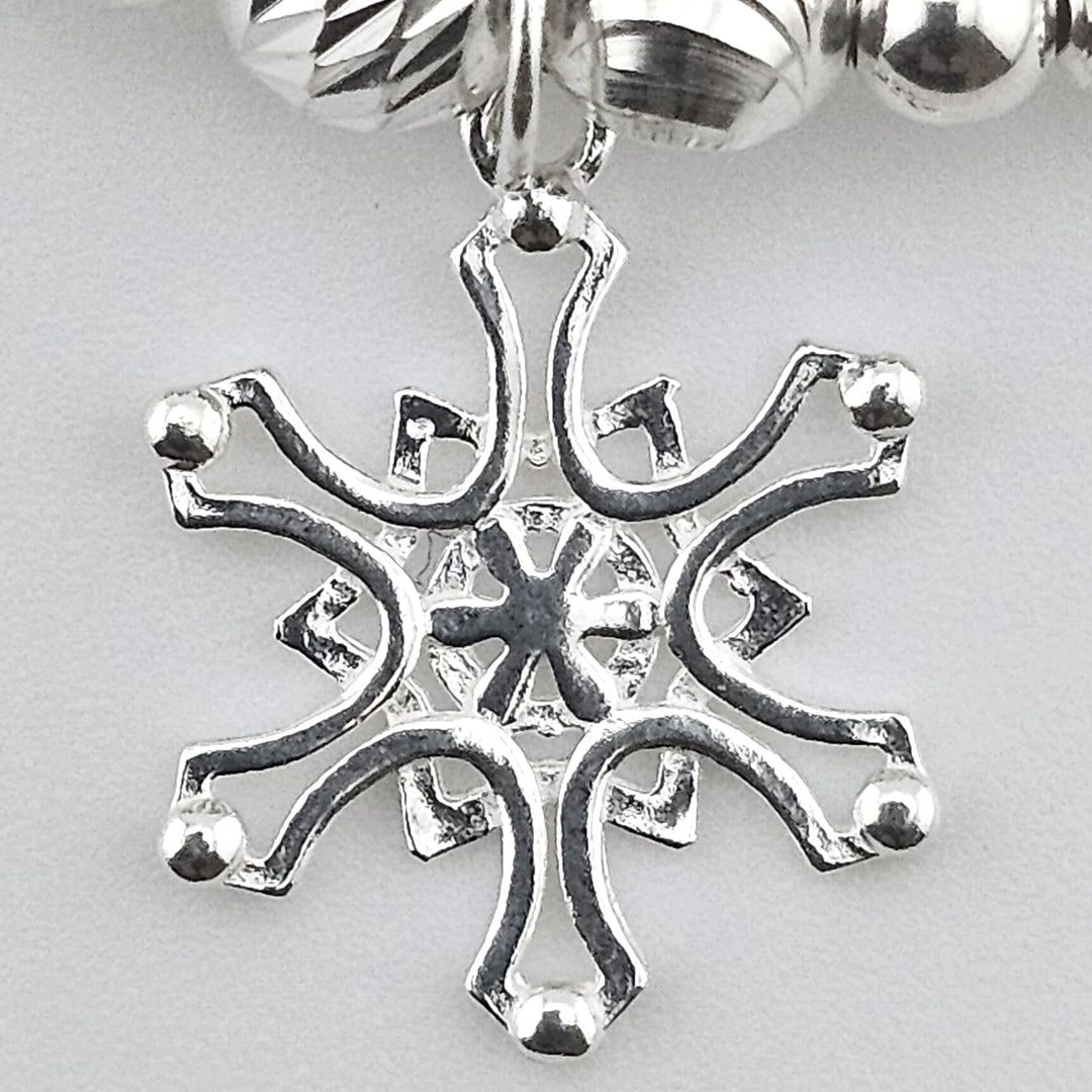Close-up of sterling silver snowflake charm.
