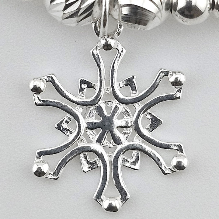 Close-up of sterling silver snowflake charm.