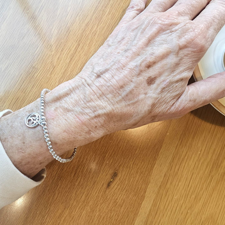 Sterling Silver Aries Zodiac Bracelet by Bessie Bae on wrist.