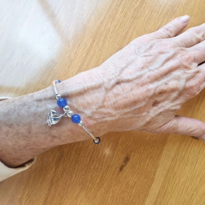 Sterling Silver and Blue Agate Sailboat Bracelet by Bessie Bae on wrist.