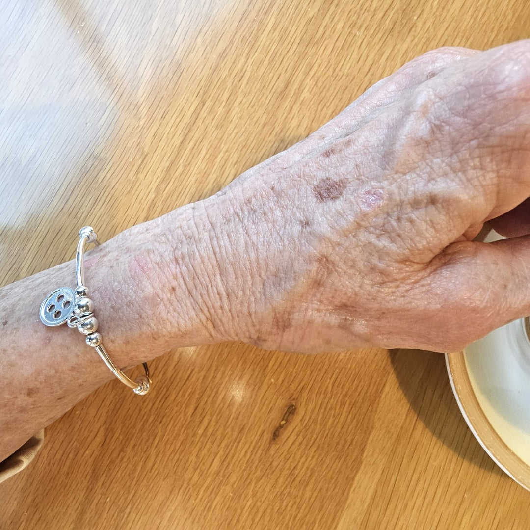 Sterling silver button bracelet on wrist.