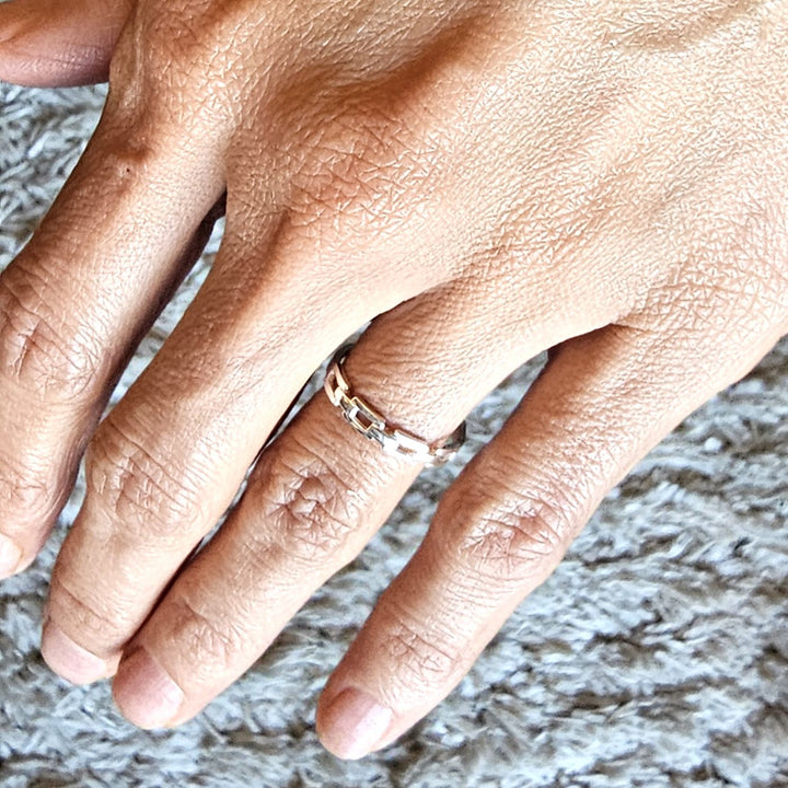 Adjustable sterling silver chain link ring worn on a hand.