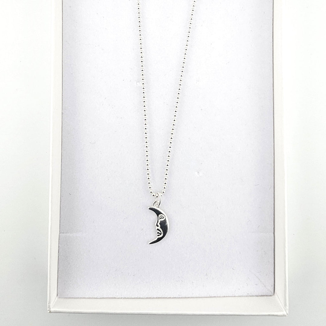 Sterling silver crescent moon necklace presented inside a white jewellery gift box.