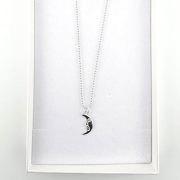 Sterling silver crescent moon necklace presented inside a white jewellery gift box.