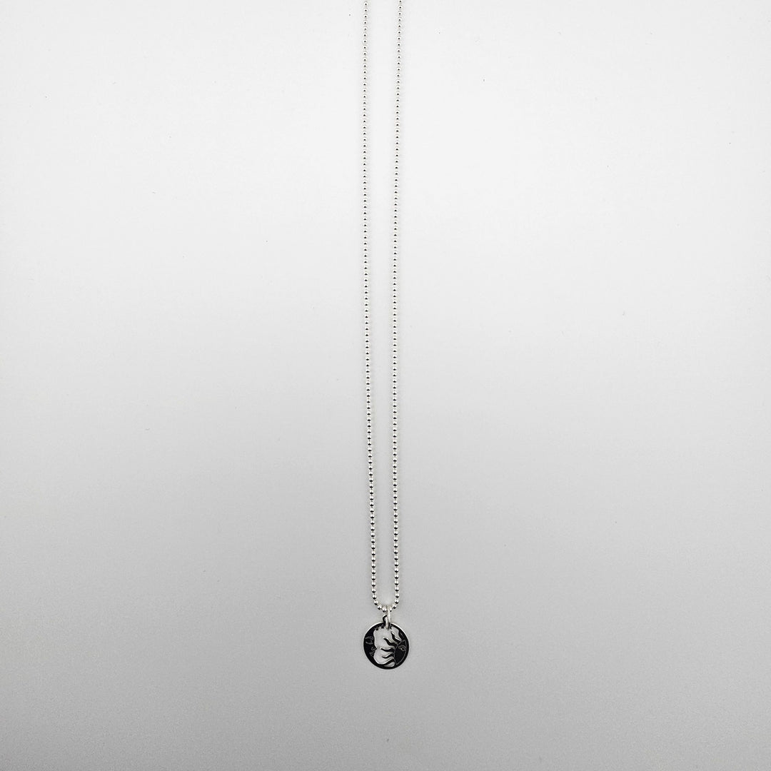 Sterling silver sun and moon harmony necklace displayed on a light background.