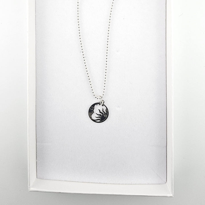 Sterling silver sun and moon necklace presented inside a white jewellery gift box.