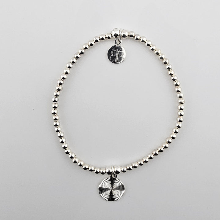 Sterling silver bracelet with sunburst charm.