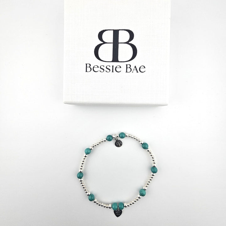 Turquoise and sterling silver anklet arranged in white gift box.