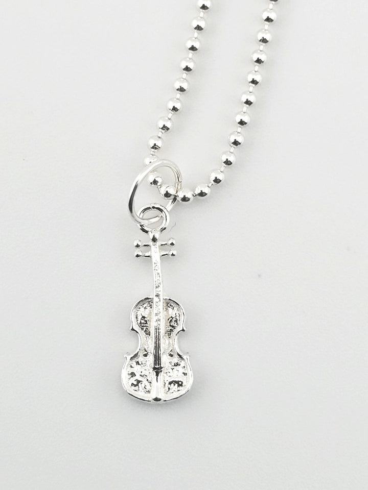Close-up of 925 sterling silver violin charm on necklace.