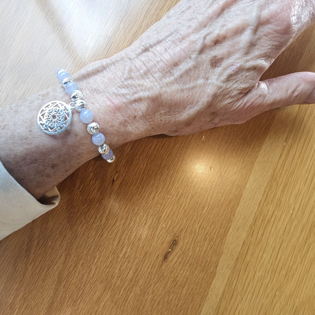 Blue Lace Agate and Sterling Silver Mandala Bracelet by Bessie Bae, shown on wrist with soft blue gemstone beads and intricate mandala charm.