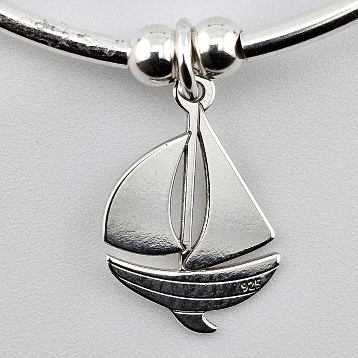 Close-up of sterling silver sailboat charm pendant marked 925.