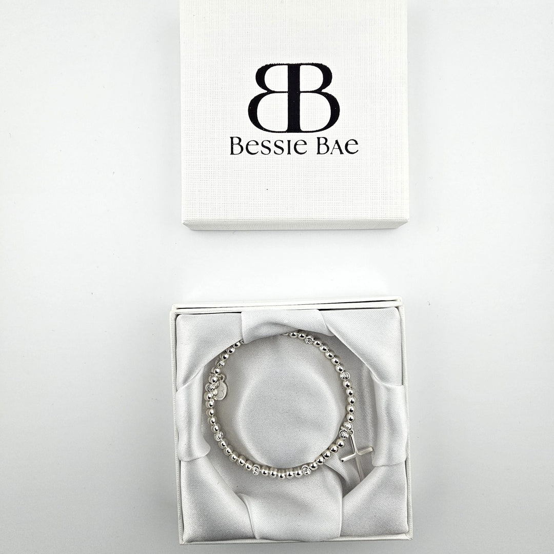 Sterling silver cross charm bracelet presented in Bessie Bae gift box.