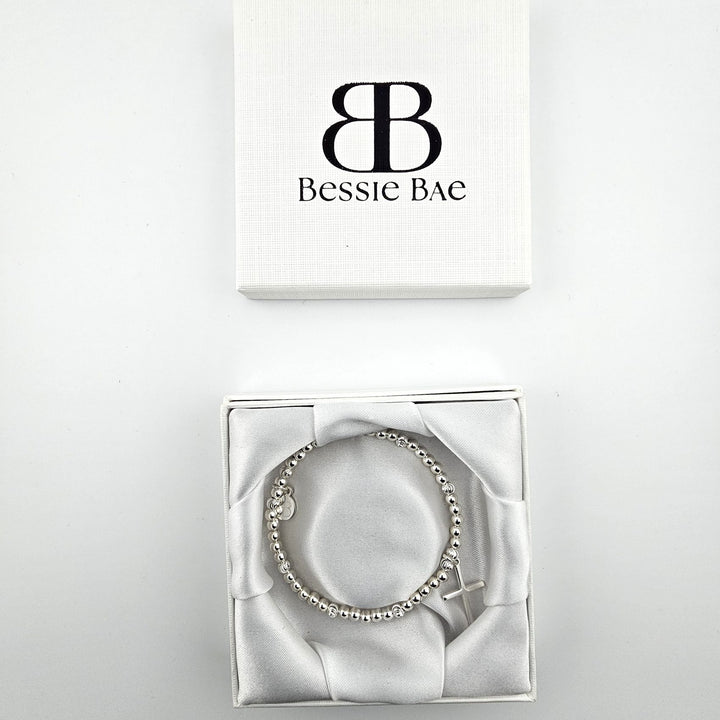 Sterling silver cross charm bracelet presented in Bessie Bae gift box.