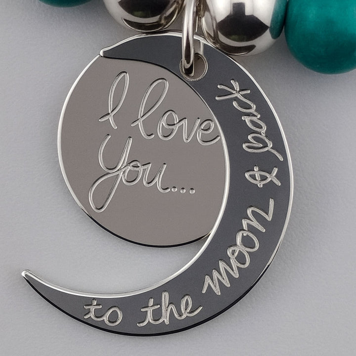 Close-up of engraved “I love you to the moon & back” pendant.