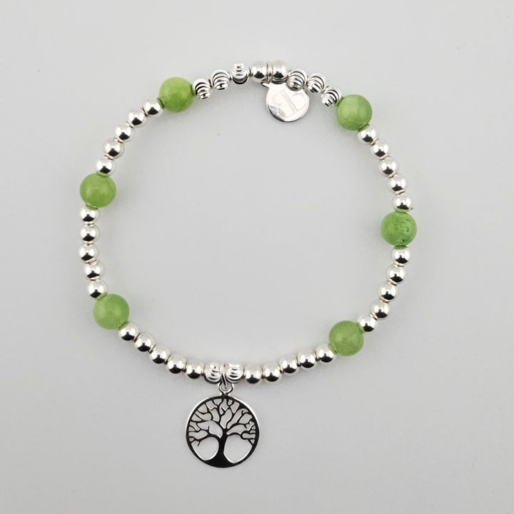 Green aventurine and sterling silver beaded bracelet with tree of life charm on white background.