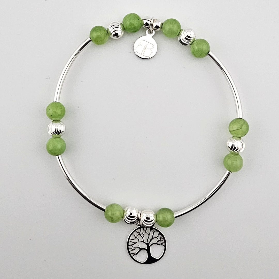 Green aventurine and sterling silver Tree of Life bracelet on white background.