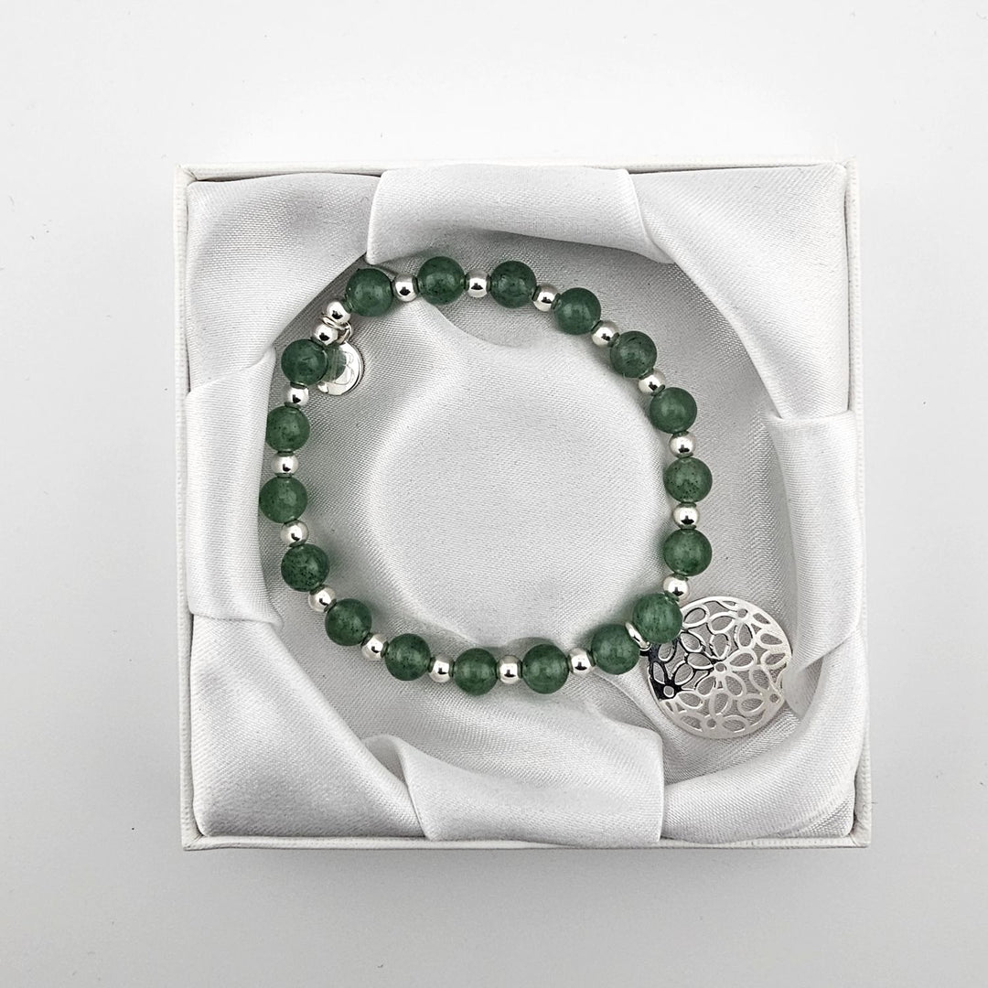 Top view of green aventurine gemstone bracelet with filigree charm in satin box.